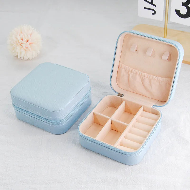 Small leather jewellery box in cross pattern, 10cm size, for earrings and rings, on a flat surface.