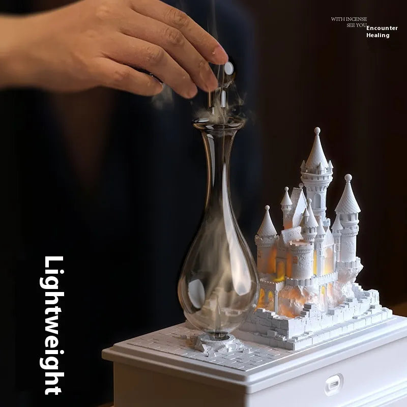 White medieval castle waterless aromatherapy machine with ambient light on a desk.