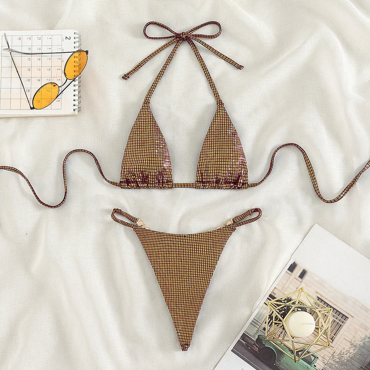 Women's solid colour blue T-back bikini set with briefs, laid flat.