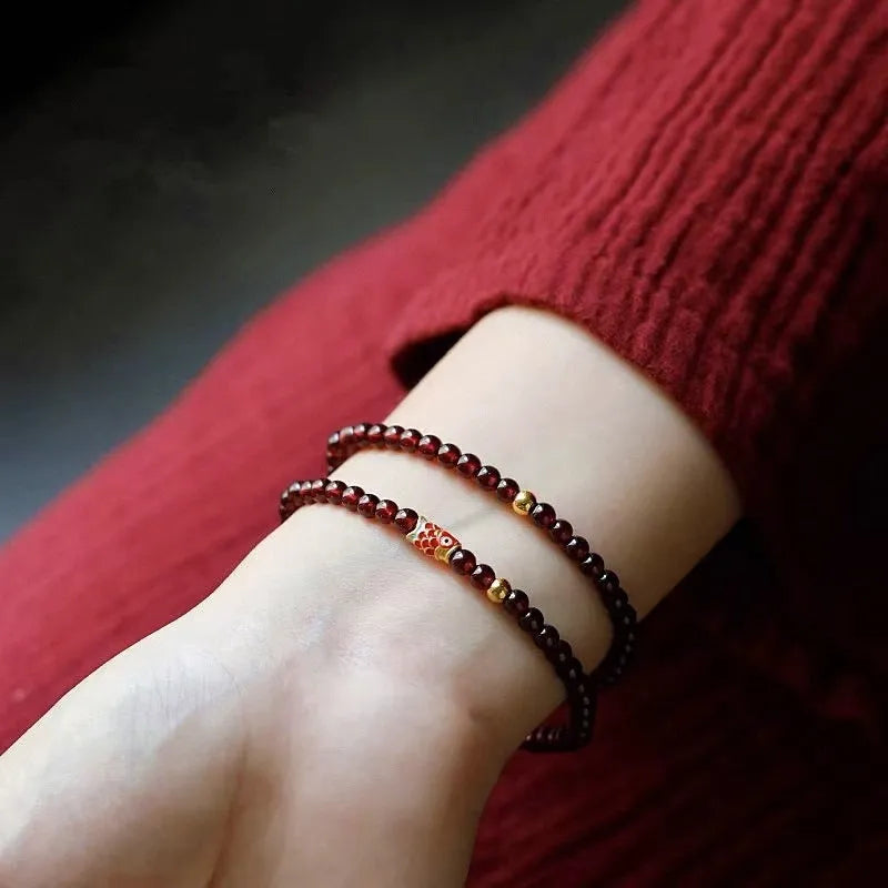 Close-up of a wine red glass bead bracelet showing micro beads and coloured glaze finish.