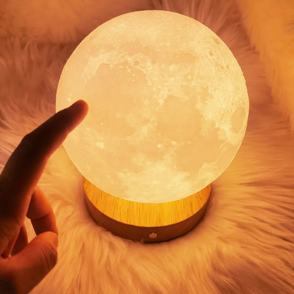 Rotating three-colour moon night light on a wooden base, showing 12cm, 15cm, and 18cm size options.