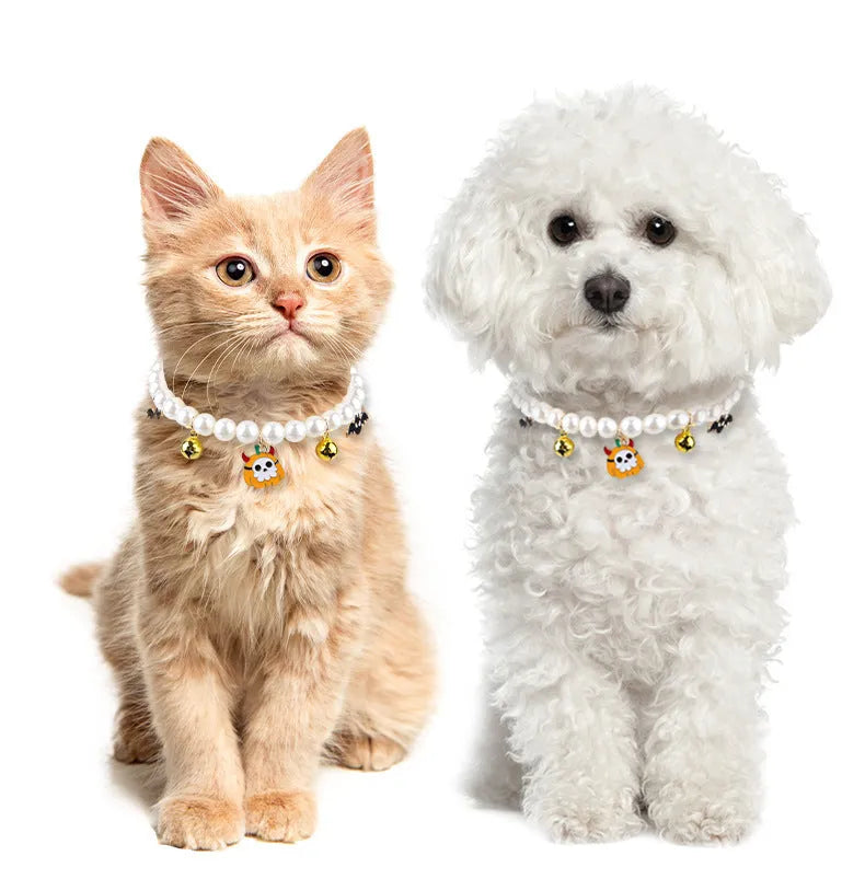Three pet necklaces: one pearl, one black and orange Halloween, and one black with orange ribbon.