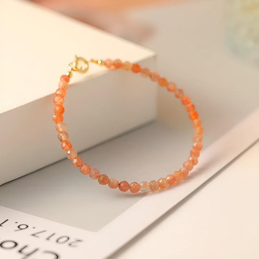 Close-up of a women's bracelet with small 3mm sunstone crystal beads on a wrist, showing its thin profile.