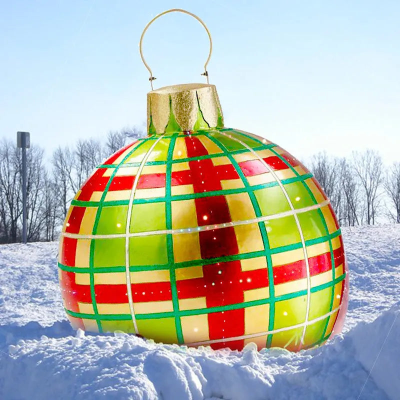 Large red and white striped inflatable Christmas ball ornament hanging on an outdoor tree