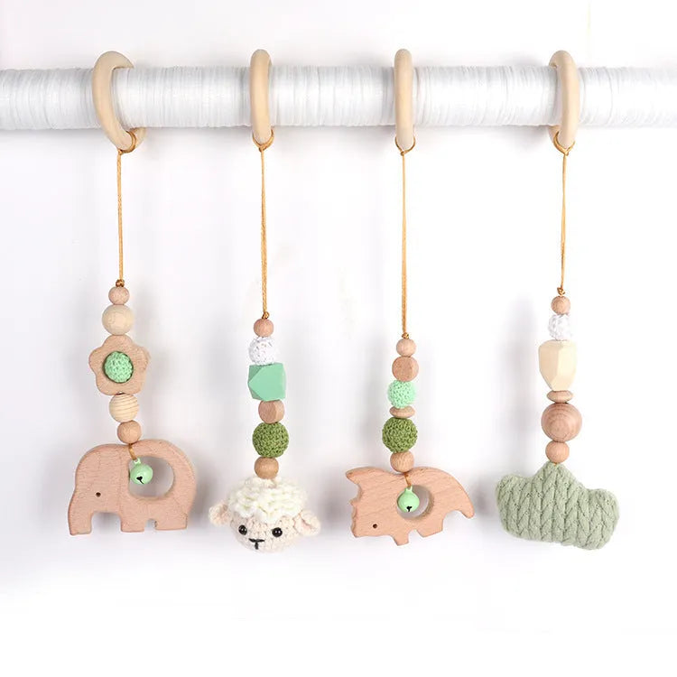Beech wood baby rattle with animal pendants in orange, 28cm length, on white background