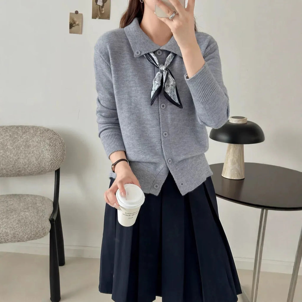 Milky white acrylic fibre cardigan sweater with a lapel scarf and long sleeves laid flat