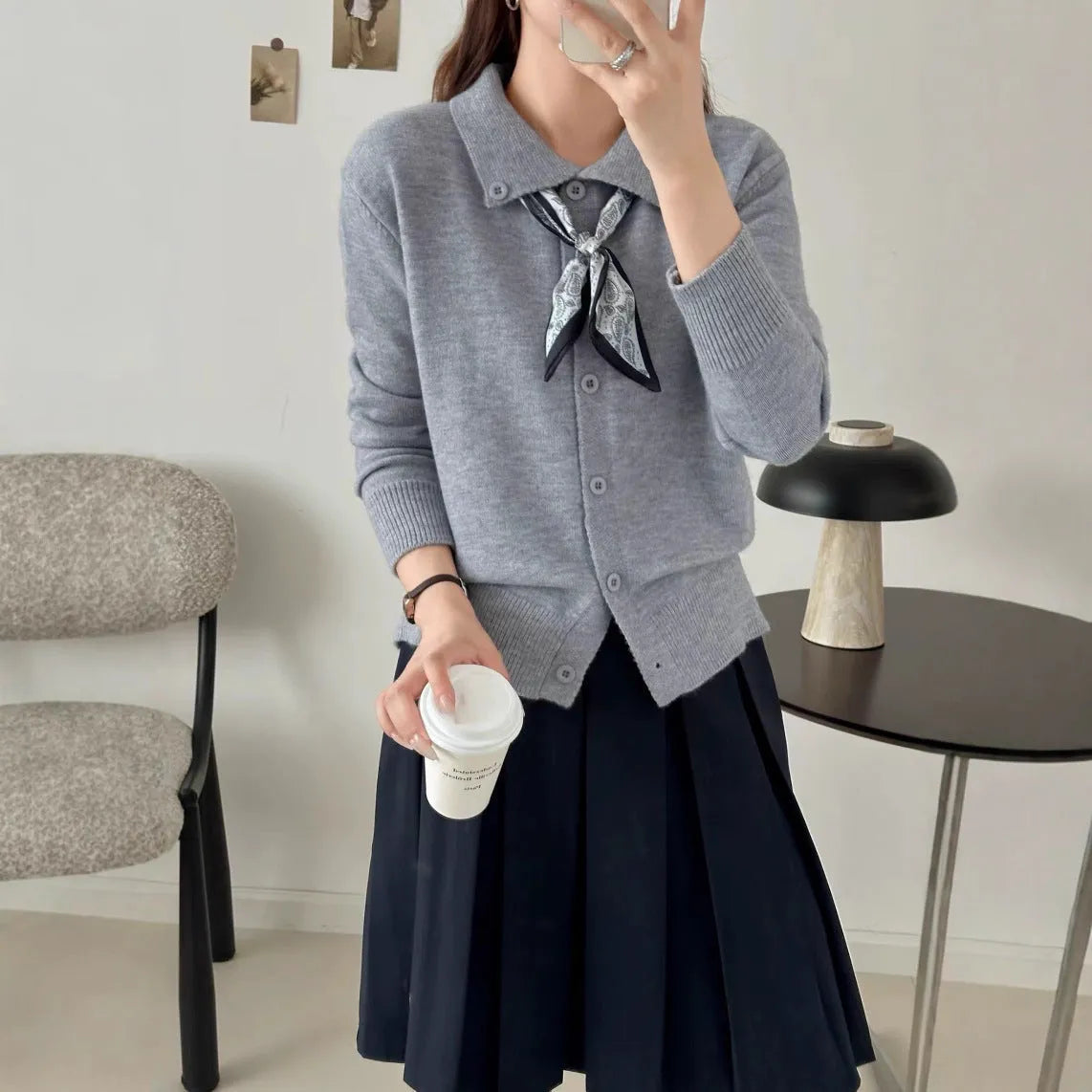 Milky white acrylic fibre cardigan sweater with a lapel scarf and long sleeves laid flat
