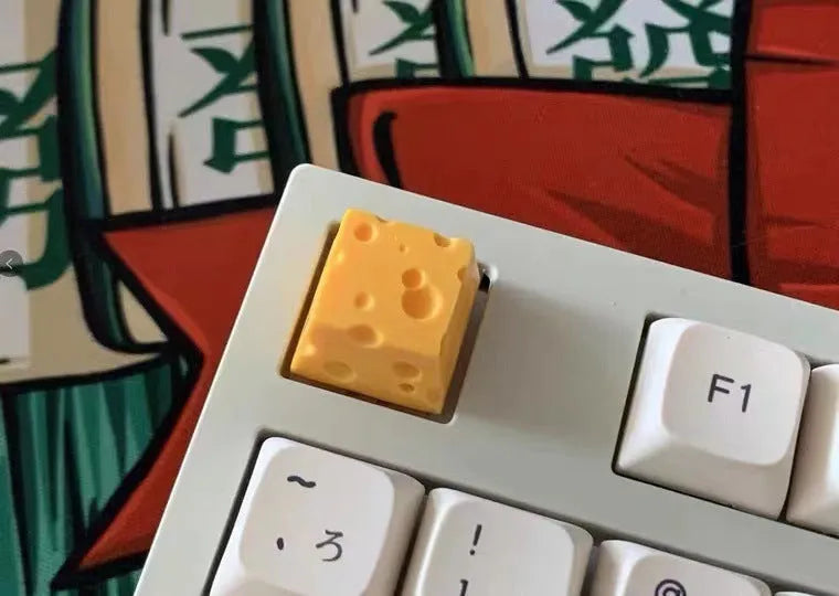 Yellow resin mechanical keyboard keycap with a detailed cheese design for MX-style switches.