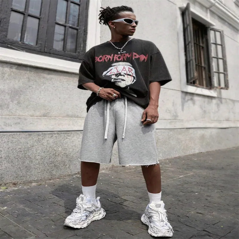 Men's straight leg polyester trousers in black, shown in a streetwear style pose.