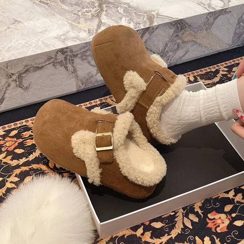 Baotou semi-drag fleece slippers in brown and camel with faux fur lining, closed toe, and rubber sole on a wooden floor
