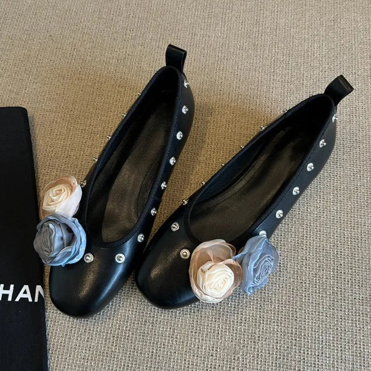 Women's silver Mary Jane flat shoes with flower rivets and a buckle strap on a sheepskin upper.