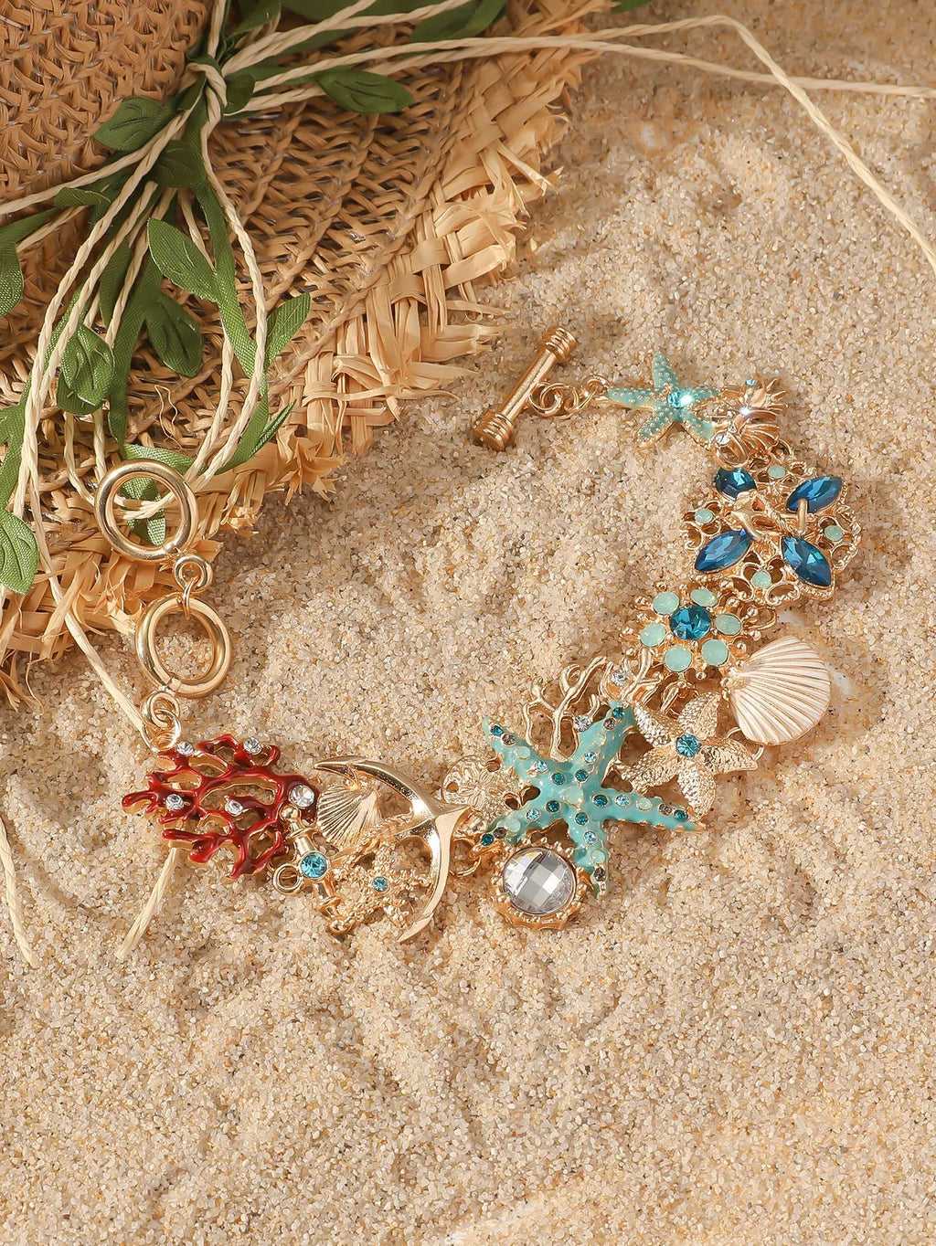 Alloy rhinestone bracelet with boat anchor and starfish design in turquoise, coral red, or coral blue.