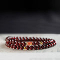 Close-up of a wine red glass bead bracelet showing micro beads and coloured glaze finish.