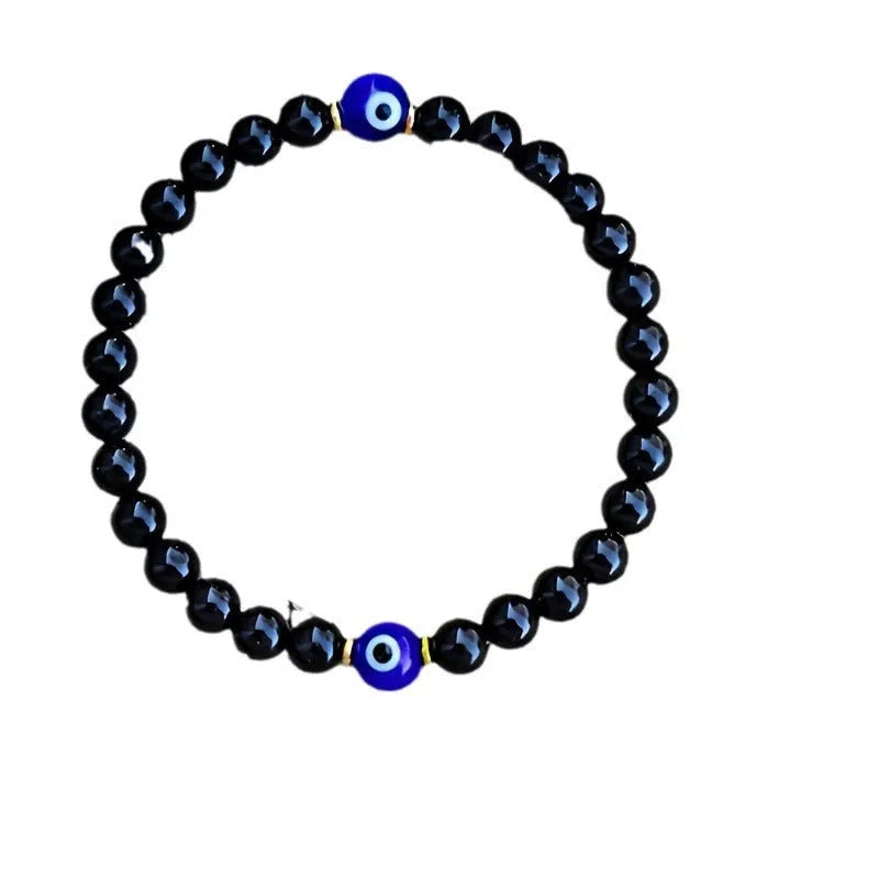 Men's black 8mm devil's eye obsidian beaded bracelet with geometric pattern on table