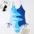 Women's blue sleeveless backless one-piece swimsuit with striped pattern on a mannequin