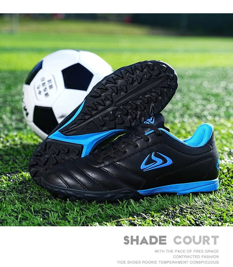 Low-top outdoor soccer shoes in a black and blue broken nails colourway on a turf background.