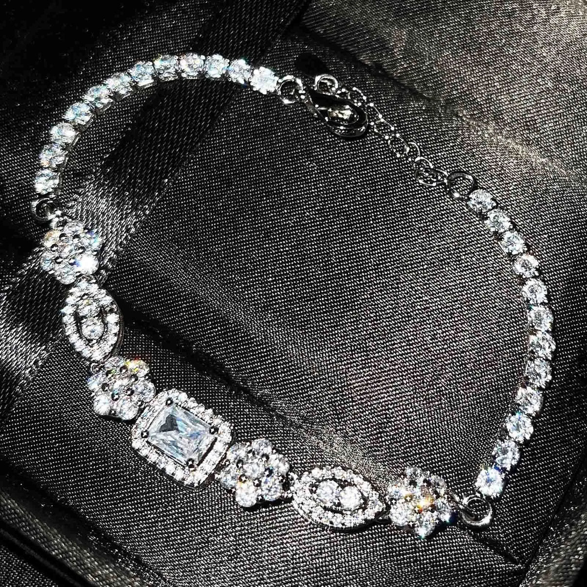 Women's silver-plated geometric zircon bracelet in white gold tone on wrist, close-up view