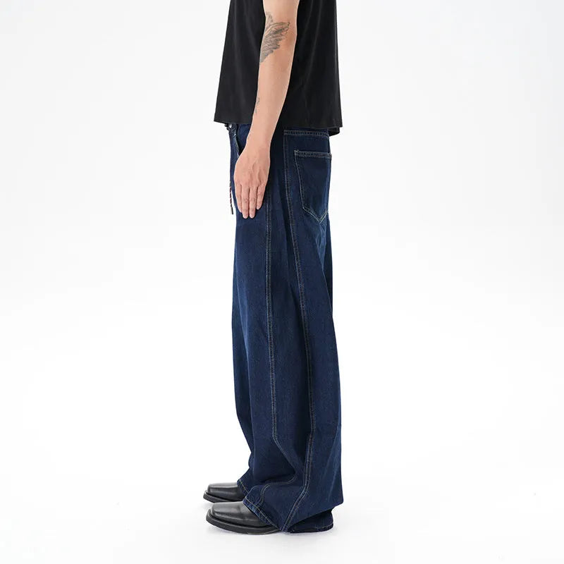 Dark blue washed distressed wide leg machete jeans on a model, showing the denim fabric and relaxed fit.