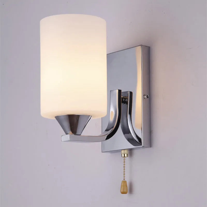 Chrome-finished modern wall lamp with glass shade, shown in single head configuration.