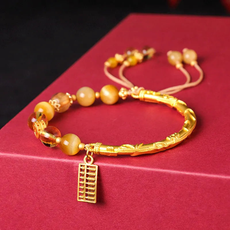 Women's beaded bracelet with tigereye, citrine, and yellow tower crystal beads in a diamond pattern.