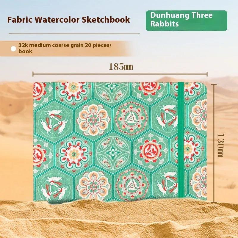 Feiluniao handmade fabric watercolour notebook with illustrated cover, open to show blank paper pages.