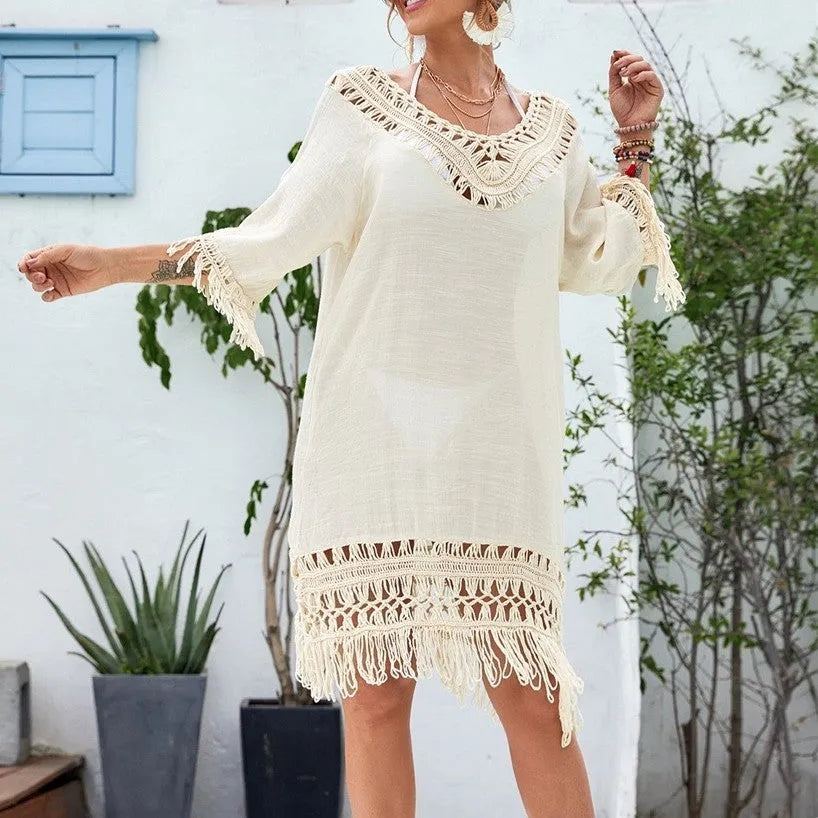 Apricot crocheted patchwork beach dress on a hanger showing textured knit and mid-length skirt.