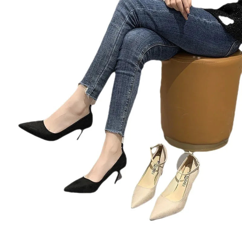 Women's black and creamy white stiletto heel pumps with a buckle fastening.