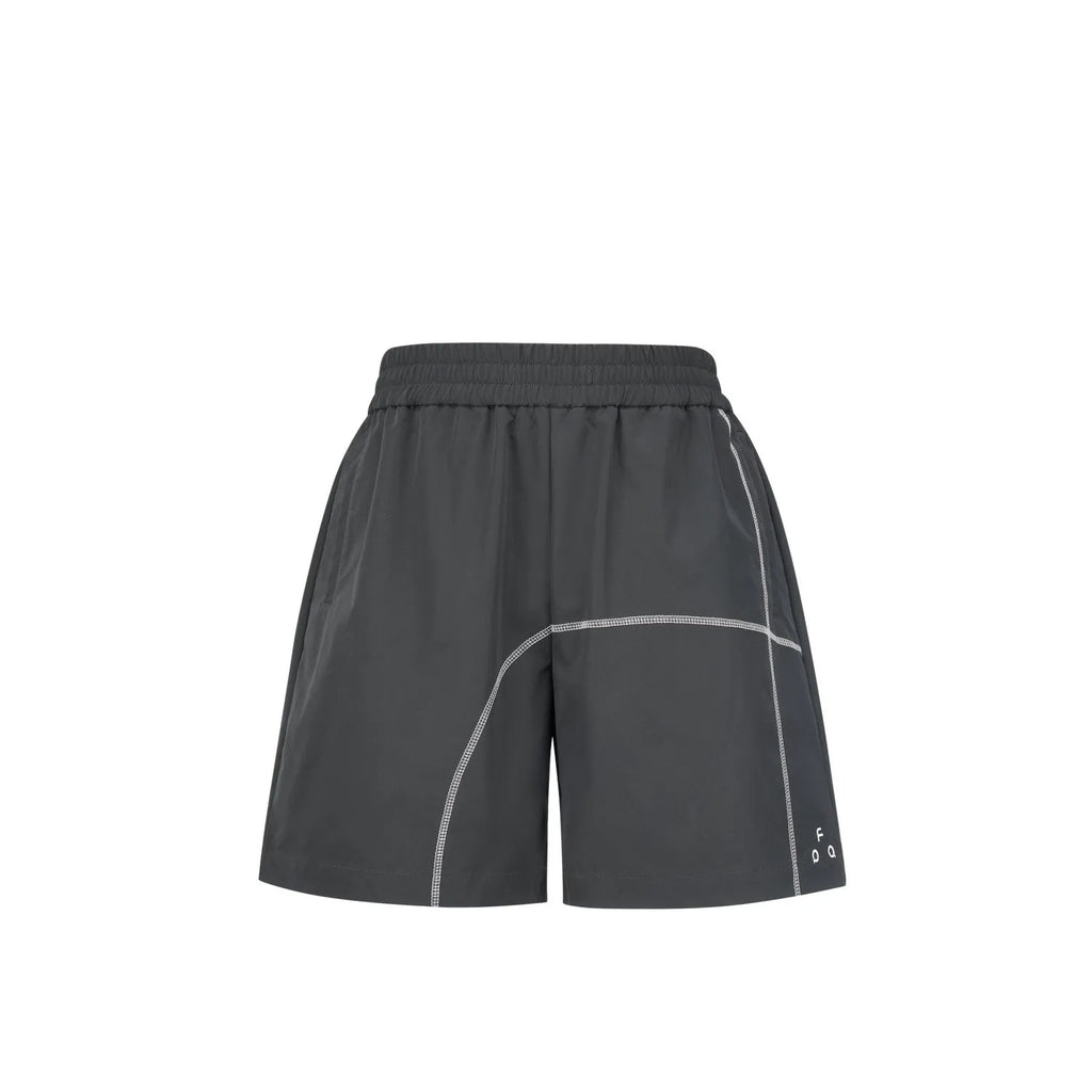Man wearing retro-style light-coloured drawstring shorts with a loose fit, on a beach.