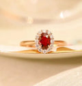 Gold Pigeon silver-plated ring with red blood gemstone and flower pattern, side view on white background