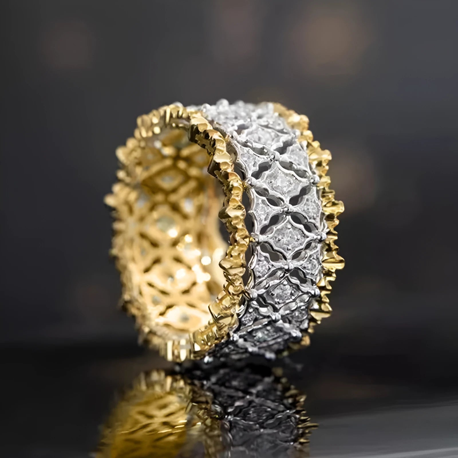 Geometric two-tone gold zircon ring on a plain background showing its round centrepiece and band detail