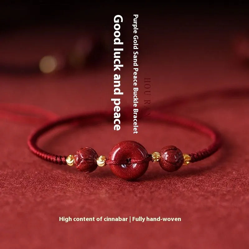 Traditional cinnabar bracelet with a heart-shaped peace buckle clasp on a red rope.
