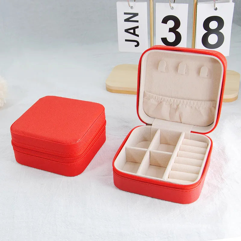 Small leather jewellery box in cross pattern, 10cm size, for earrings and rings, on a flat surface.
