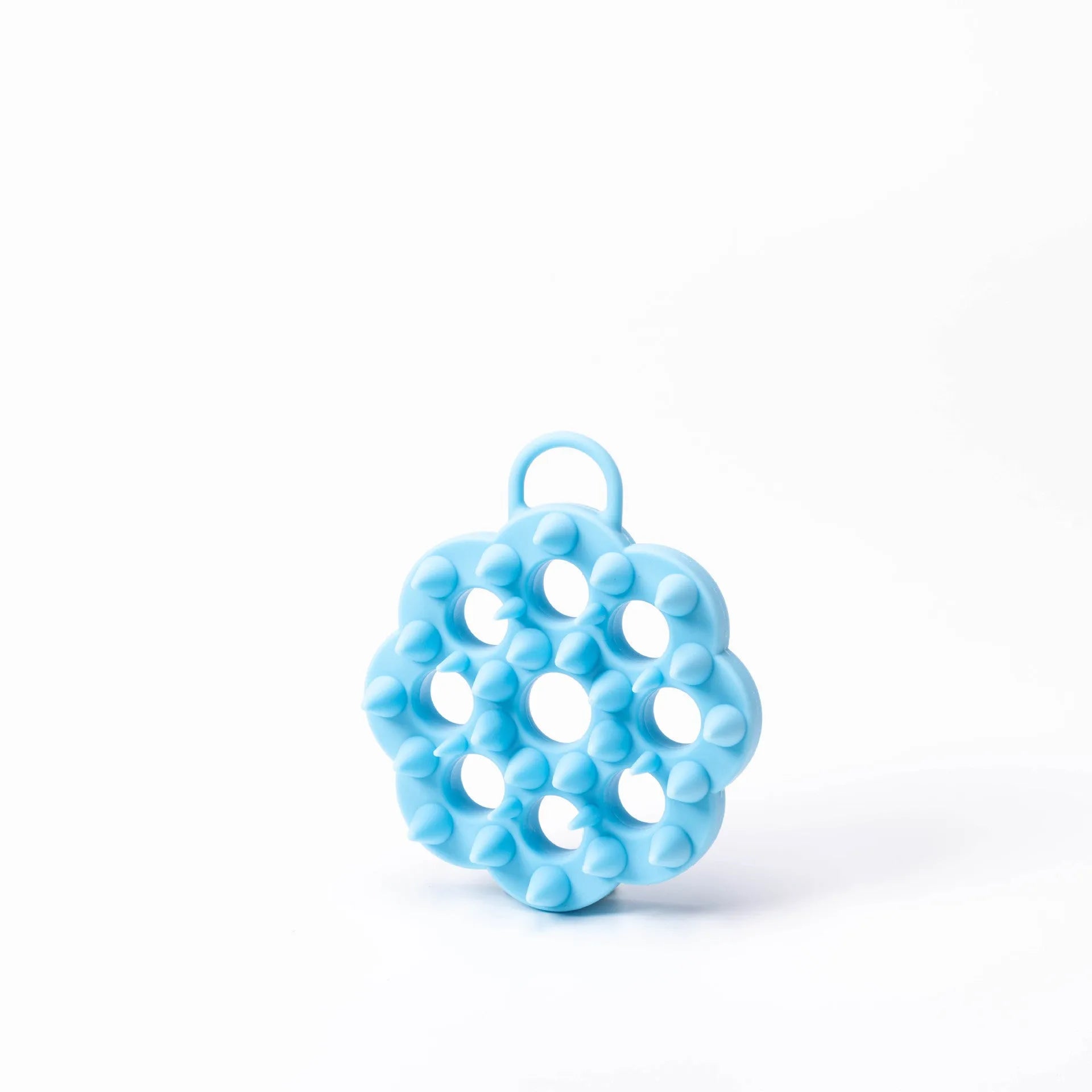 Blue silicone pet grooming brush with soft bristles and an ergonomic massage handle on a white background.