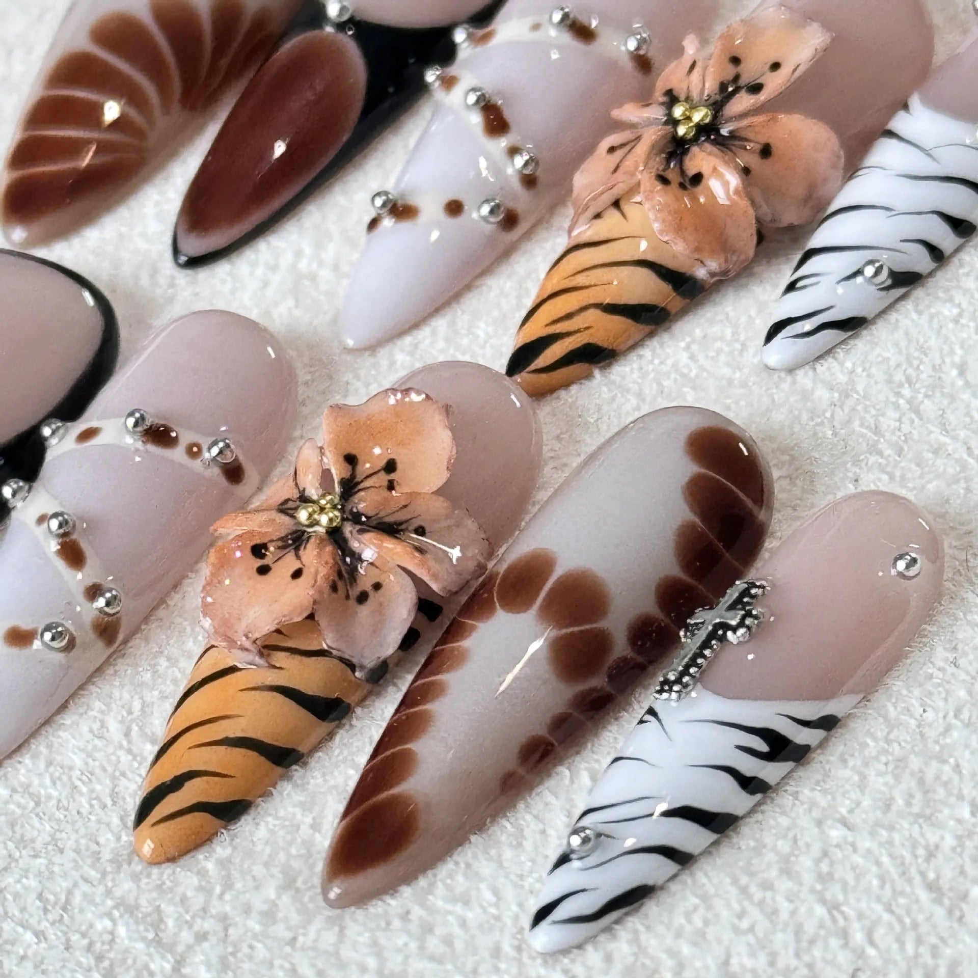 Leopard print false nails with cross and flower patterns in French style, shown in sizes XS S M L.