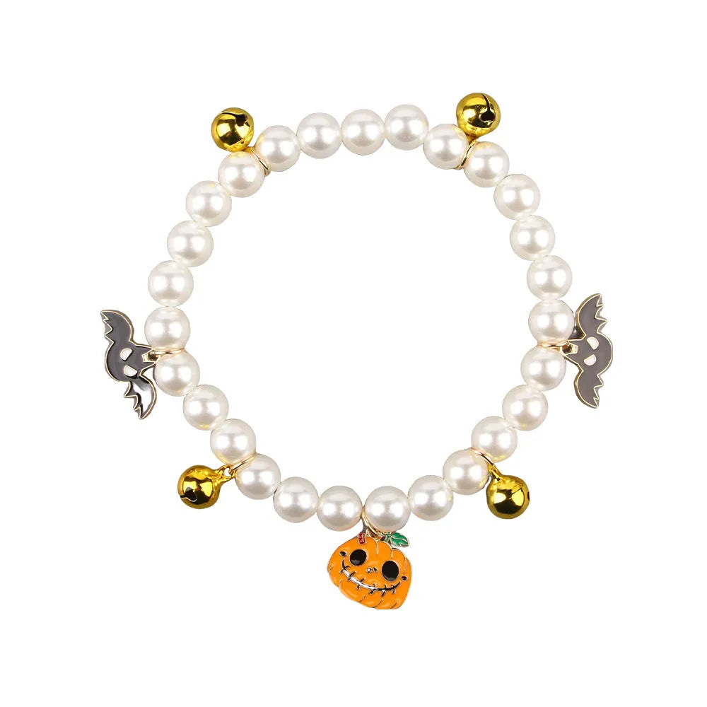 Three pet necklaces: one pearl, one black and orange Halloween, and one black with orange ribbon.