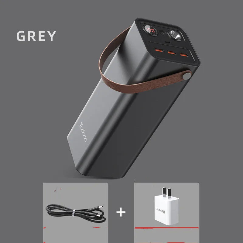 Black portable power bank with solar panel, showing USB ports and car charging socket