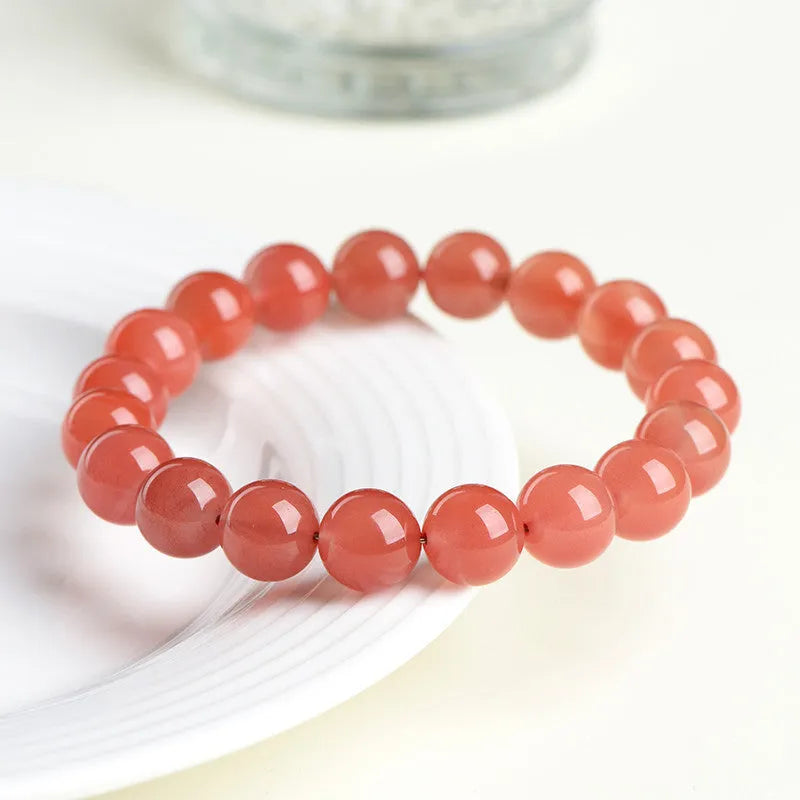 Natural South Cherry Red Agate bracelet with polished beads on an elasticated cord.