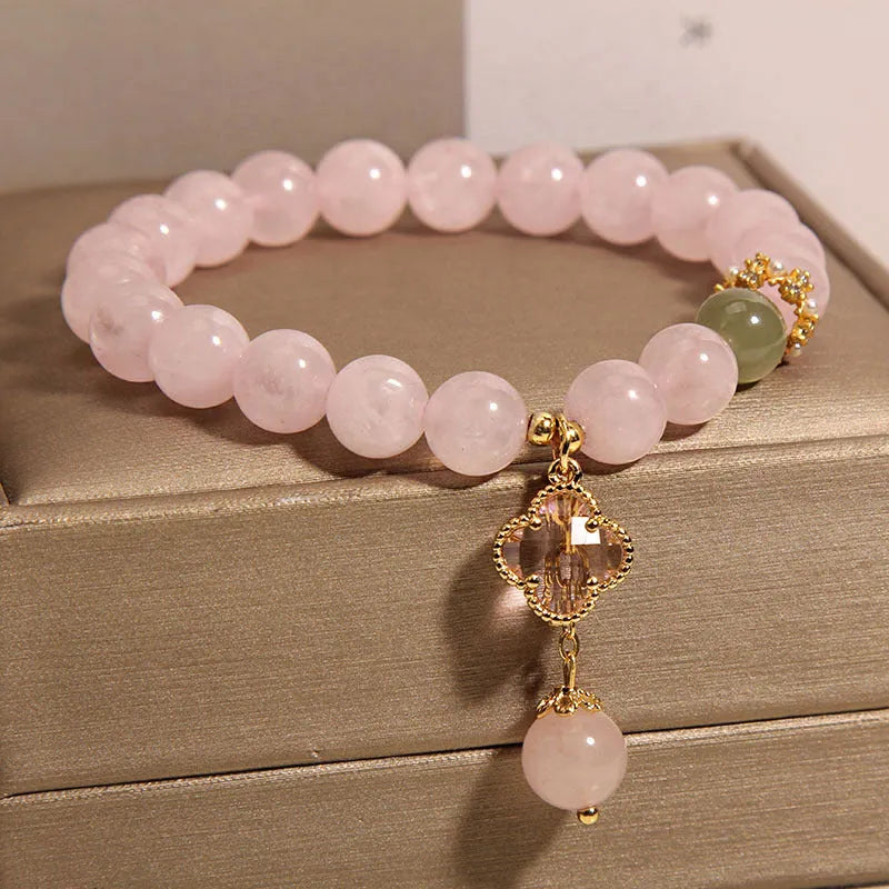Pink crystal bracelet for women with a four-leaf clover pendant and sparkling rhinestones.