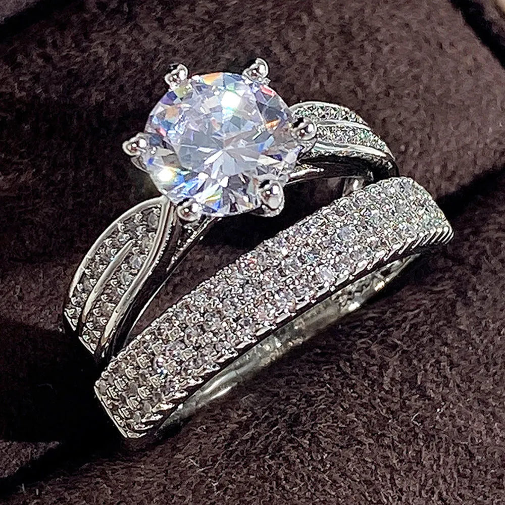 Geometric white gold colour alloy wedding ring bracelet with round detail on a finger.