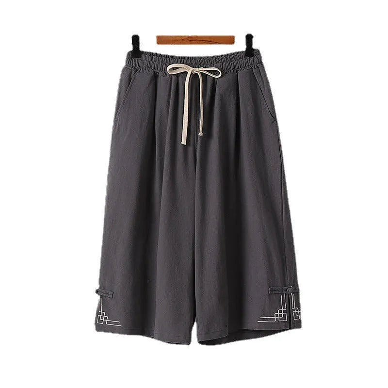 Wide leg cotton leisure shorts in apricot colour with embroidery detail, shown on a hanger.