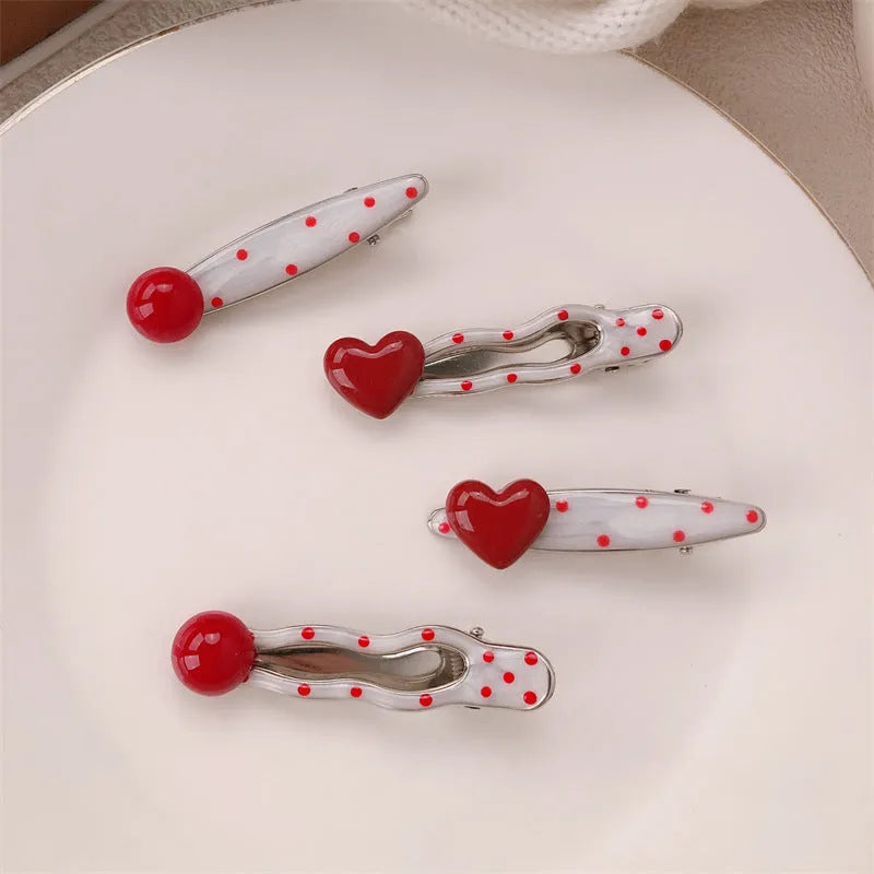 Red love heart-shaped plastic hair clip with retro dots and a willow leaf silhouette on a white background.