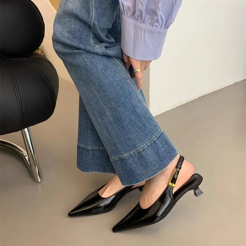 Women's black leather pointed-toe shoes with a thin low heel and an ankle strap.