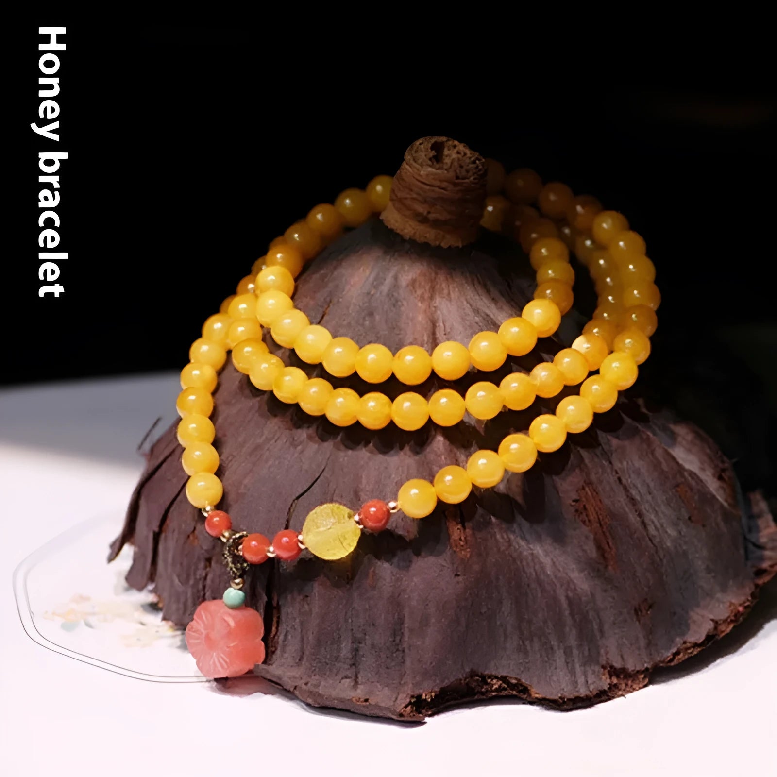 Yellow amber bracelet with 5mm round beads and animal zodiac design on a wrist.