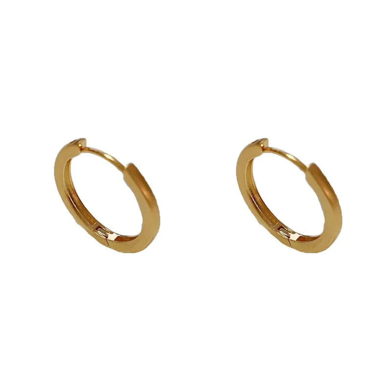 Women's geometric round eyelet ear clips in gold and silver colours, showing front view.