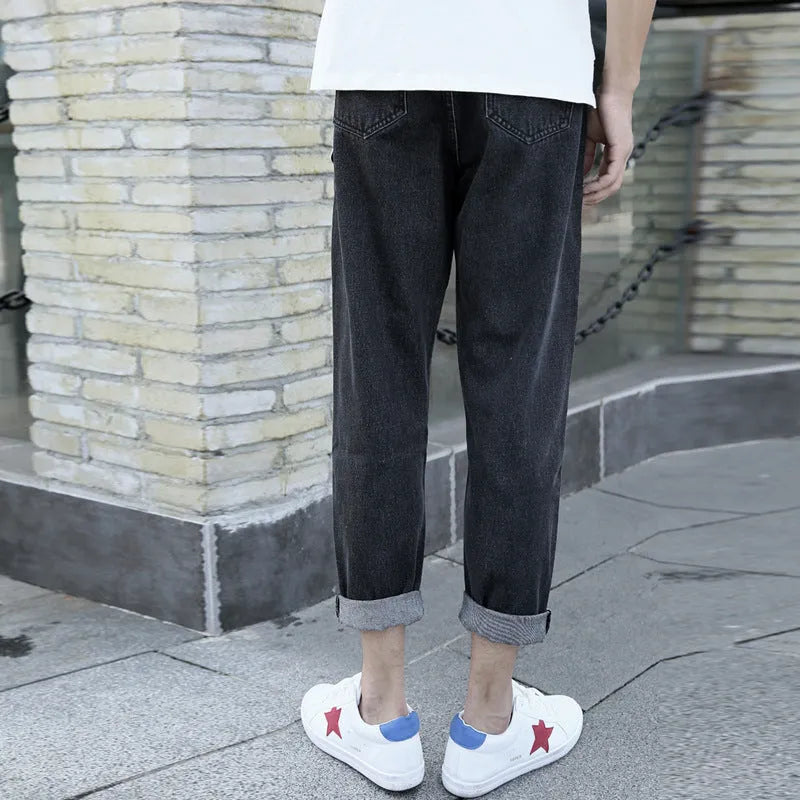 Men's black cotton straight-leg jeans with loose harem fit on adult male model