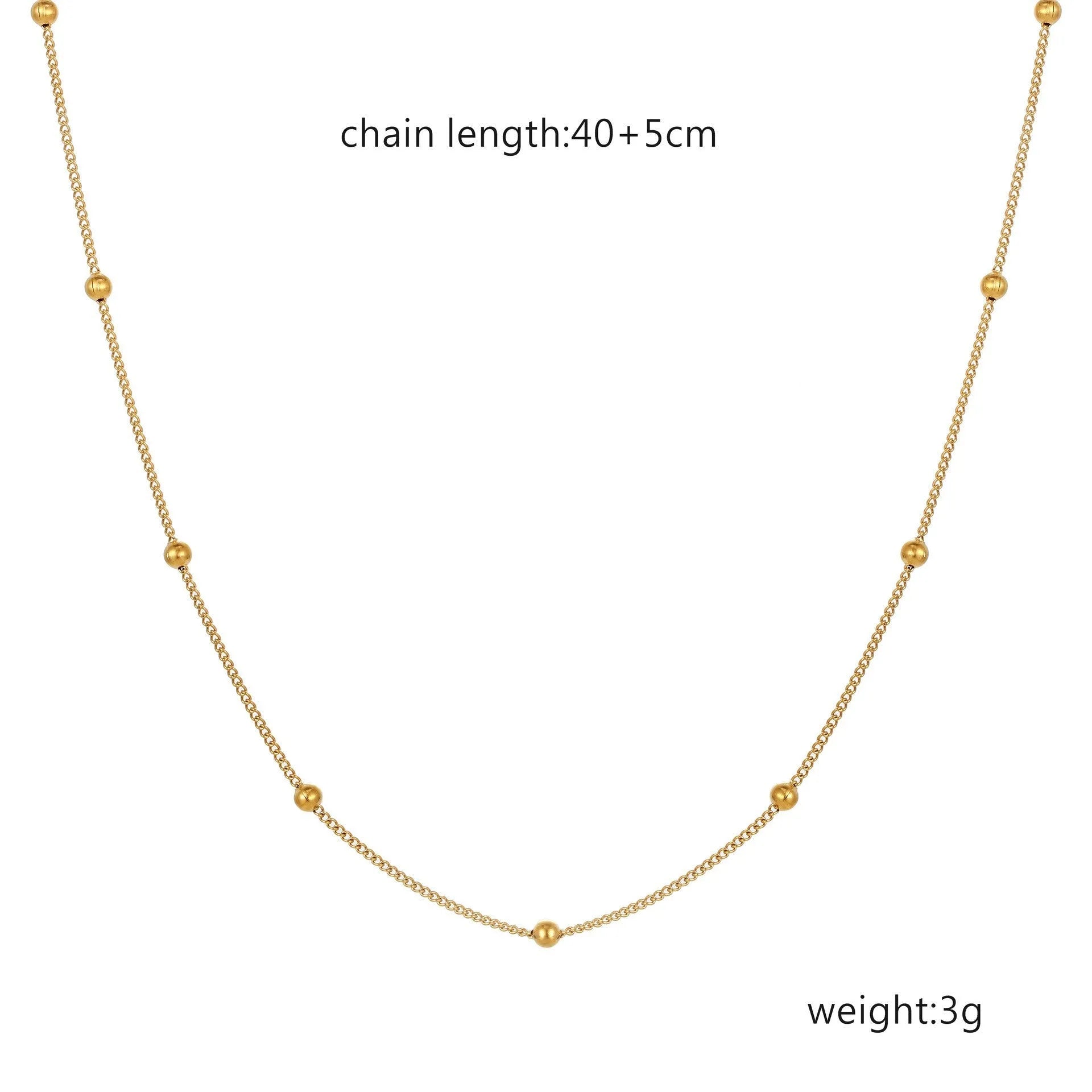 Women's stainless steel necklace with 18K gold hollow round pendant and O-link chain on neutral background