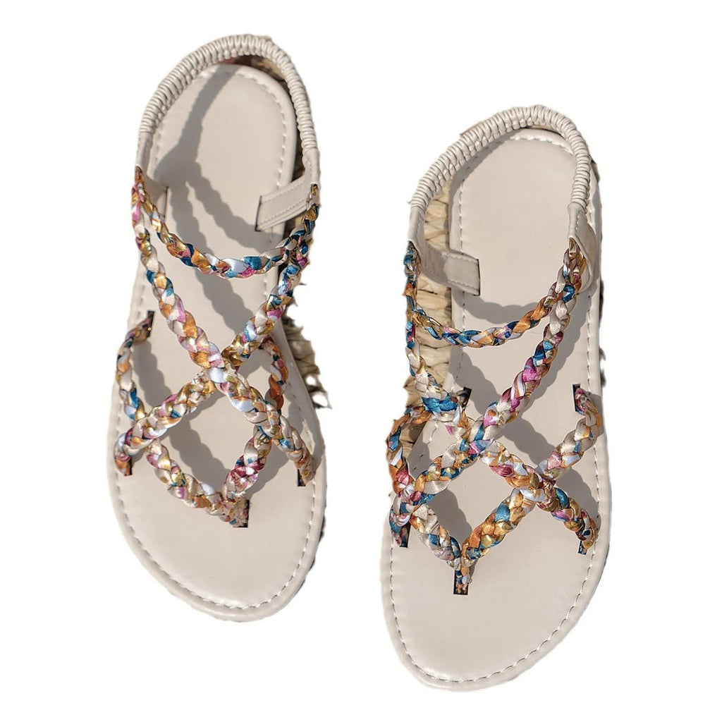 Pair of adult flat sandals with elastic band fastening, cloth upper, and round toe in white.