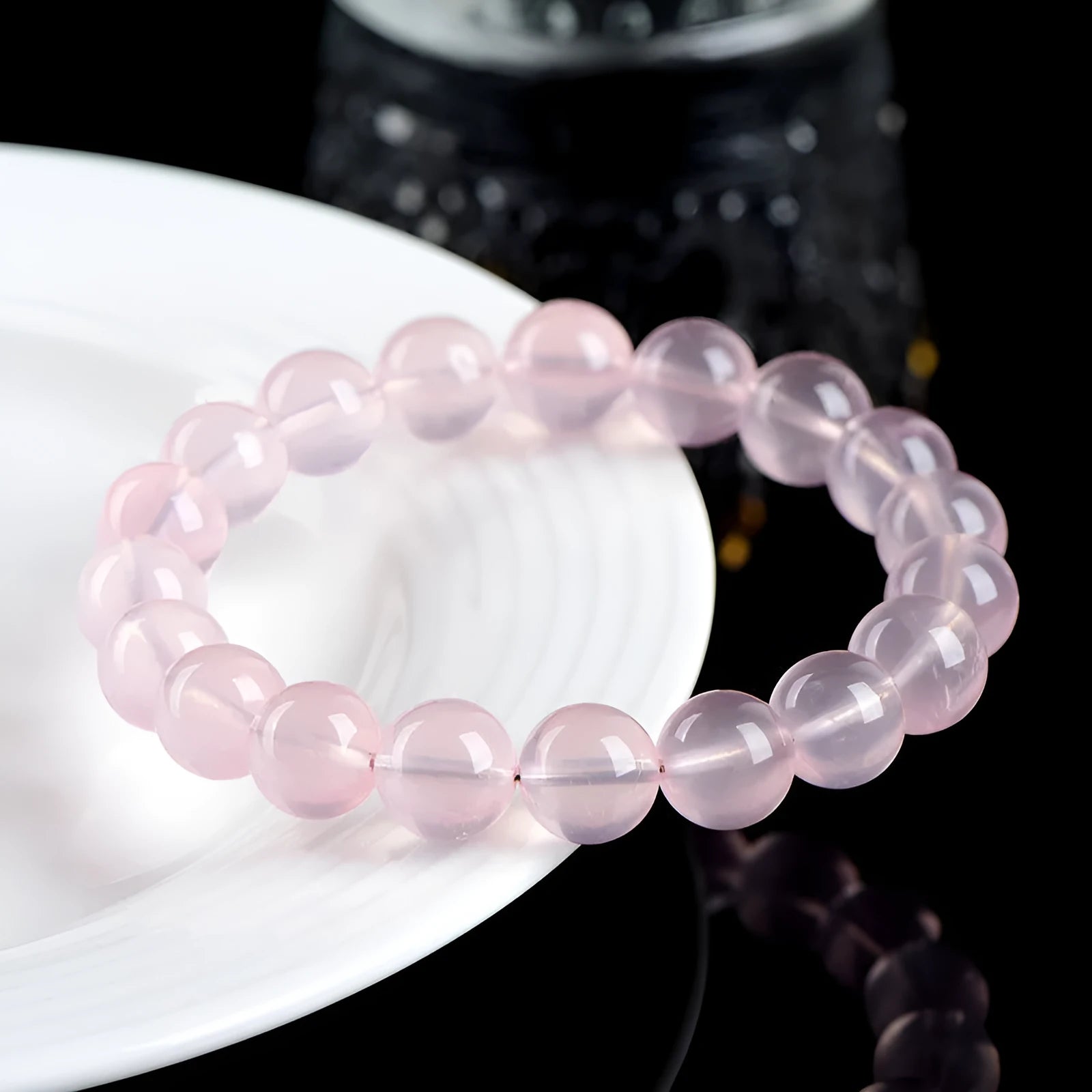 A polished natural starlight crystal round bead bracelet in pink, shown in a single circle design.