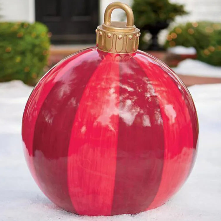 Large red and white striped inflatable Christmas ball ornament hanging on an outdoor tree