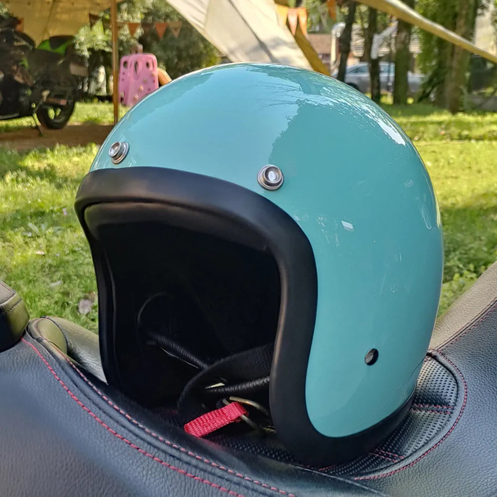 A retro-style grey half helmet for motorcycle riding, shown on a stand.
